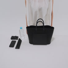 Load and play video in Gallery viewer, 500mlのペットボトル、スマートフォン、コンパクトカメラ、ペンケースをCOURTNEY ORLA(コートニーオーラ)のINVERSE TOTE M(ハンドバッグ)に入れる様子