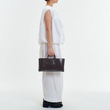 Load image into Gallery viewer, COURTNEY ORLA（コートニーオーラ）のCURVE WIDE TOTE S BLACK/CHOCOLATE BROWN（ハンドバッグ）のモデル着用写真
