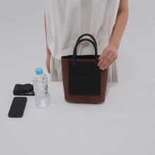 Load and play video in Gallery viewer, 500mlのペットボトル、スマートフォン、コンパクトカメラをCOURTNEY ORLA（コートニーオーラ）のINVERSE TOTE S（ハンドバッグ）に入れる様子
