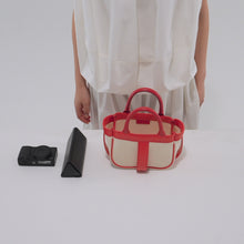 Load and play video in Gallery viewer, コンパクトカメラ、ペンケースをCOURTNEY ORLA（コートニーオーラ）のFRAME TOTE S（ハンドバッグ）に入れる様子
